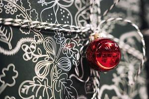 presente Natal caixa amarrado com uma corda e decorado com uma vermelho Natal bola foto