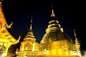 fechar-se e colheita noite tela do dourado tailandês têmpora e pagode com lindo iluminação foto