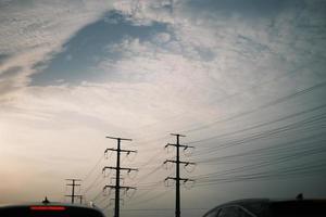 uma céu coberto com nuvens e Telefone postes foto