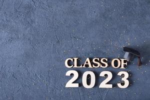 classe do 2023 conceito. de madeira número 2023 com graduado boné em cimento fundo foto