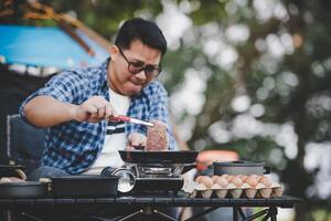 retrato de homem viajante asiático óculos bife de porco fritando foto