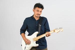 retrato de jovem asiático na camisa azul com guitarra eletrônica isolada no fundo branco foto
