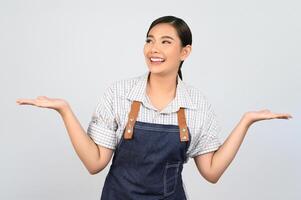 jovem asiática de retrato em uniforme de garçonete com postura de palma aberta foto