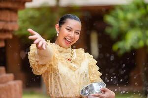 retrato mulher bonita no festival songkran com traje tradicional tailandês foto