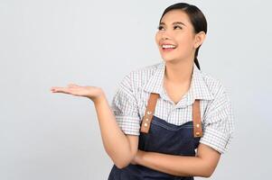 jovem asiática de retrato em uniforme de garçonete com postura de palma aberta foto