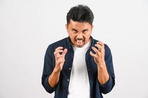 retrato de jovem asiático desapontado na camisa azul irritado com raiva em gesto furioso isolado no fundo branco foto