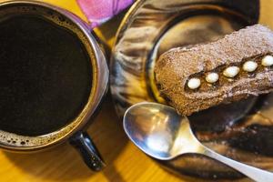 chocolate rum bolo e uma copo do café , sobremesa decorado com creme e cacau, café pausa foto