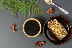 uma copo do café e uma bolo em uma pires em uma Sombrio fundo topo Visão foto