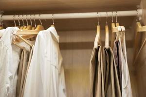 roupas, Camisetas, vestidos aguentar em uma cabide dentro a casa armário de roupa foto