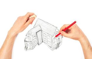 mãos desenhando grande casa em uma branco foto