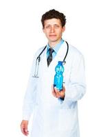 retrato do uma masculino médico segurando garrafa do água em branco fundo foto