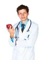 retrato do uma masculino médico segurando vermelho maçã em branco foto