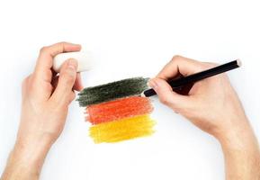 do homem mãos com lápis desenha bandeira do Alemanha em branco foto