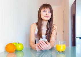 jovem mulher dentro a cozinha ouvindo para música foto