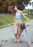 jovem bonita e elegantemente vestida com bicicleta foto