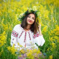jovem lindo sorridente menina dentro ucraniano traje com uma guirlanda em dele cabeça foto