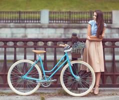 jovem lindo, elegantemente vestido mulher com bicicleta, verão e estilo de vida foto