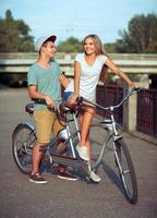 feliz casal equitação uma bicicleta dentro a cidade rua foto