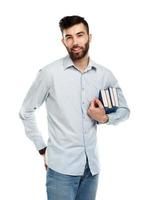 jovem barbudo sorridente homem com livros dentro mãos em branco foto