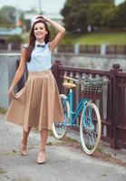 jovem bonita e elegantemente vestida com bicicleta foto