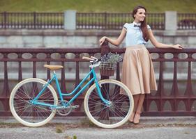 jovem bonita e elegantemente vestida com bicicleta foto