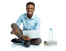 feliz africano americano Faculdade aluna sentado com computador portátil em branco foto