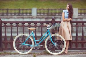 jovem lindo, elegantemente vestido mulher com bicicleta dentro a parque ou ao ar livre foto