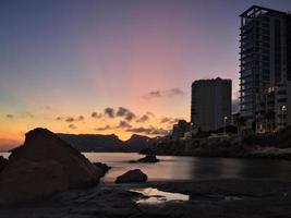 torre de apartamento em uma praia tranquila ao pôr do sol