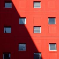 janelas na fachada vermelha de um edifício foto