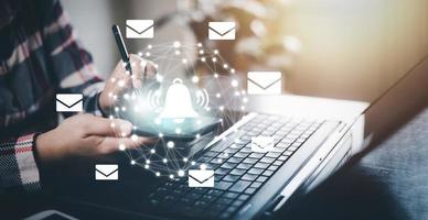 empresária segurando smartphone com ícones de comunicação, ícone de carta, ícones de e-mail e e-mail de boletim informativo e proteja suas informações pessoais ou e-mails de spam, contato do call center de atendimento ao cliente. foto