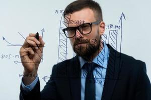 homem desenha vários crescimento gráficos, calculando perspectivas para sucesso dentro uma moderno vidro escritório foto