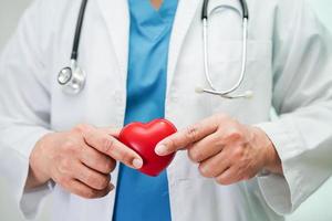 médico de mulher asiática segurando coração vermelho para saúde no hospital. foto