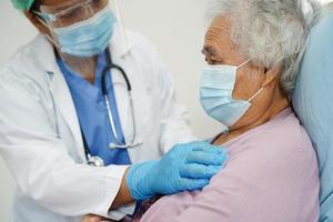 médico verifica paciente idosa asiática usando uma máscara para proteger o coronavírus covid. foto