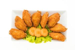 asas de frango frito em um prato branco foto