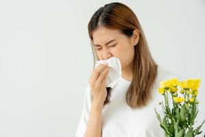 pólen alergias, jovem mulher espirros dentro uma lenço ou sopro dentro uma limpar, alérgico para selvagem Primavera flores ou flores durante Primavera. alérgico reação, respiratório sistema problemas, escorrendo nariz. foto