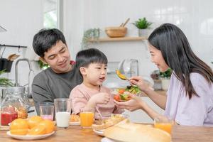 Atividades juntos durante a feriados. pais e crianças estão tendo uma refeição juntos durante a feriados. Mather preparar leite para filho em manhã, aproveitar, fim de semana, vago, família tempo, feliz. foto