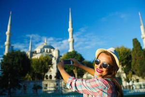 menina dentro a chapéu fazer foto de a Smartphone perto a azul mesquita, Istambul