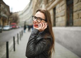 empresária caminhando baixa a rua enquanto falando em inteligente telefone foto