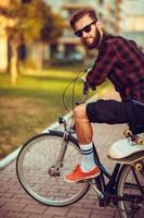 homem dentro oculos de sol equitação uma bicicleta em cidade rua foto