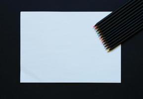 em branco papel e colorida lápis em Preto fundo foto