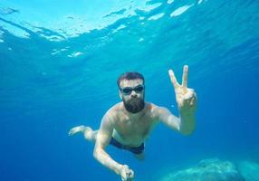 homem fazendo embaixo da agua selfie tiro com selfie bastão dentro mar foto