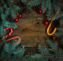 Natal fronteira com abeto árvore, cones, Natal decorações e doce bengala em de madeira Pranchas foto