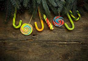 Natal fronteira com abeto árvore galhos, pinho cones e doce bengala em rústico de madeira Pranchas foto