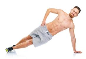 esporte atraente homem fazendo ginástica exercícios em a branco foto