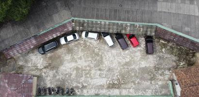 zangão fotos a partir de acima Vejo carros e motocicletas estacionamento dentro uma renda casa