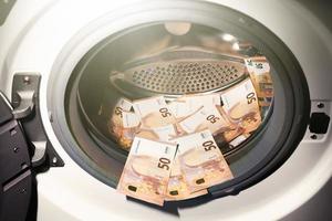 50. euro notas dentro lavando máquina. dinheiro lavagem símbolo. imposto evasão. ilegal financeiro transações. euro moeda foto