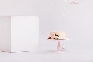 lindo bolo de creme branco decorado com vela de 2 anos e rosas em estúdio branco. festa de aniversário - conceito de um ano de nascimento, festa, celebração da vida e momentos memoráveis. foto