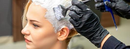 cabeleireiro aplicando branco corante para cabelo foto