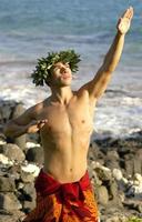 uma hula dançarino quem é masculino é usando dele mãos para gesto tradicional havaiano símbolos. foto