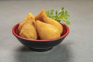 tradicional frito coxinha dentro prato em ardósia fundo, popular brasileiro lanche foto